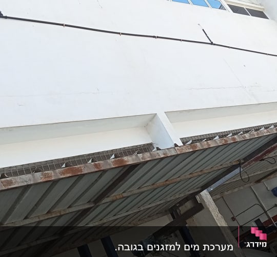צינור מים מותקן על קיר חיצוני של בניין